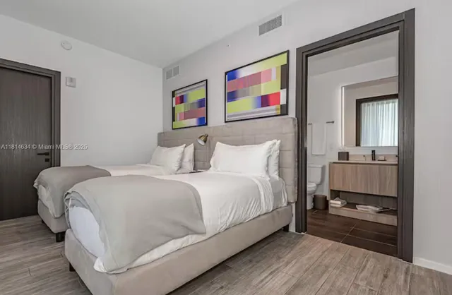 a bedroom with a bed and painting on the wall