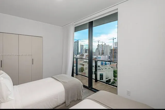 a bedroom with a bed and a large window