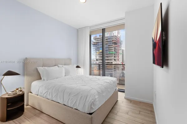 a bedroom with a large bed and a large window