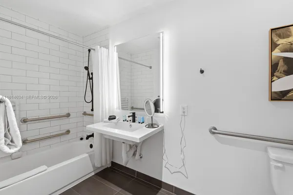 a bathroom with a double vanity sink mirror and tub