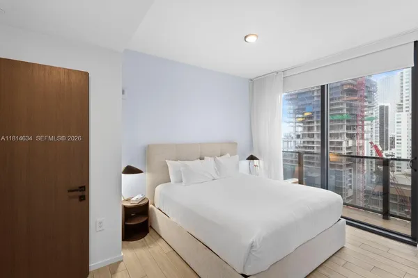 a bedroom with a bed and painting on the wall