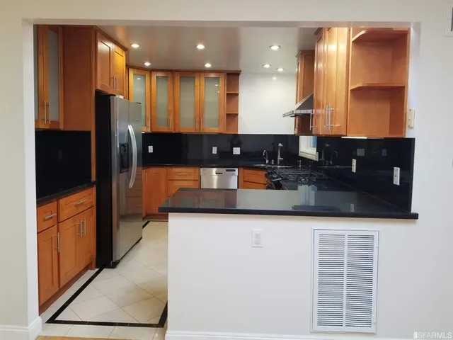 a kitchen with stainless steel appliances granite countertop a sink and a refrigerator
