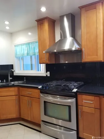 a kitchen with stainless steel appliances granite countertop a stove a sink and a microwave