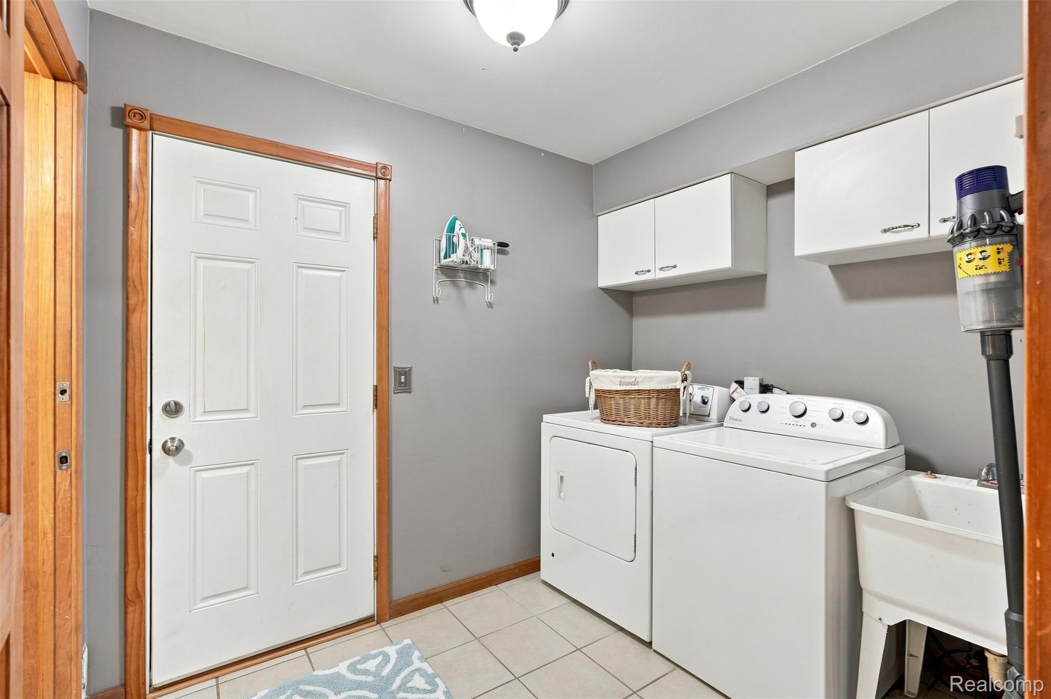 793 North Adams Road Rochester, MI 48309 - Photo 21 of 40 Laundry area featuring a utility sink, white upper cabinetry, and tile flooring