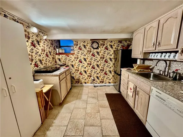 a kitchen with granite countertop a refrigerator and a stove top oven