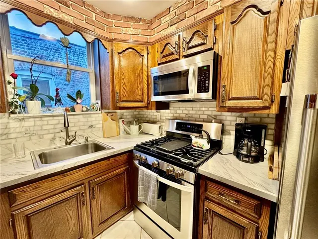 a kitchen with stainless steel appliances a sink a stove and a microwave