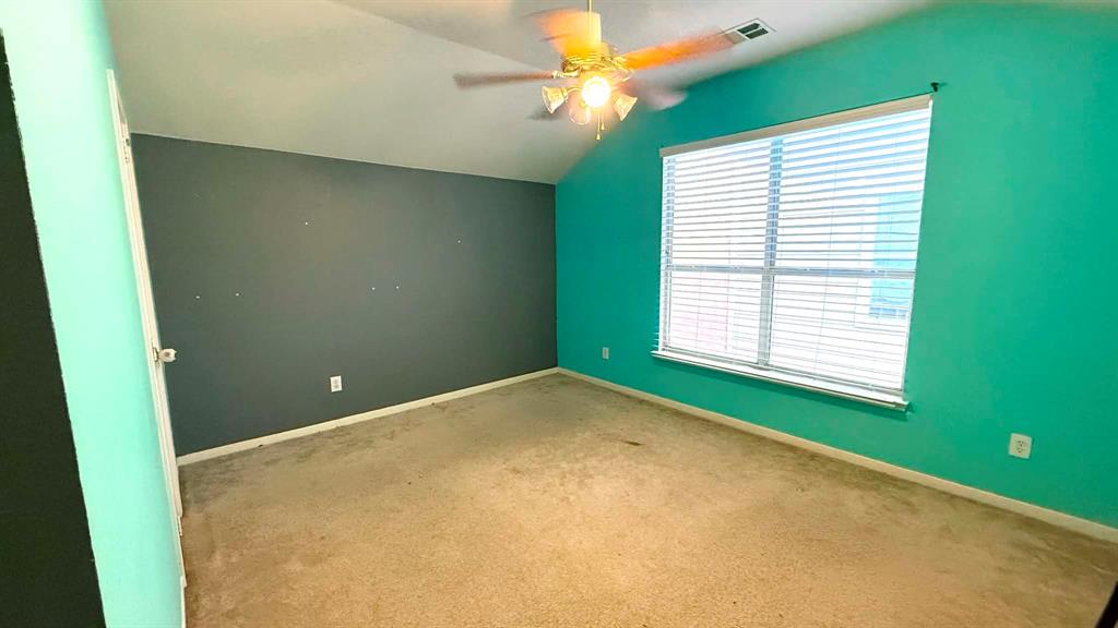 9117 Ripley Street Fort Worth, TX 76244 - Photo 24 of 31 Upstairs Carpeted bedroom featuring a large window with horizontal blinds, a vaulted ceiling, and a ceiling fan with integrated lighting