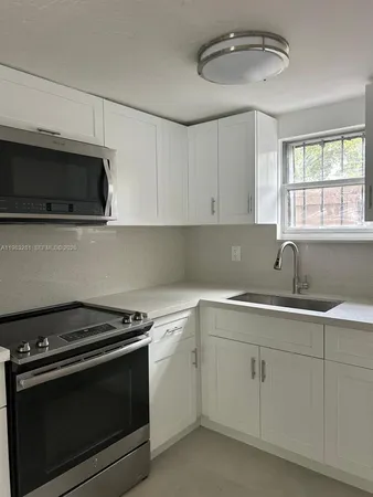 a kitchen with a sink stove and microwave