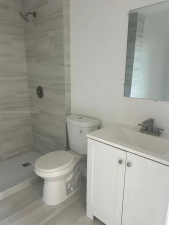 a white toilet sitting next to a bathroom sink