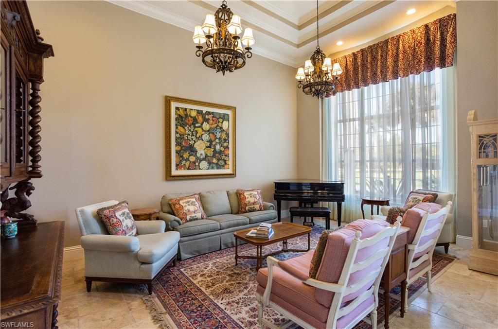 2225 23rd Street Southwest Naples, FL 34117 - Photo 13 of 44 a living room with furniture a fireplace and a chandelier