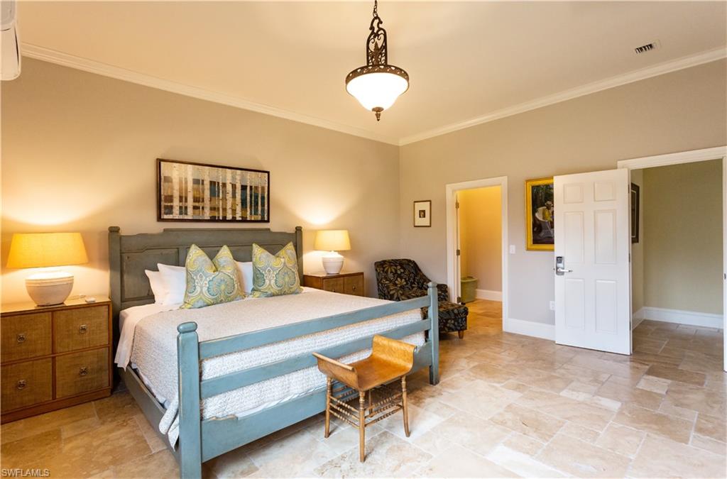 2225 23rd Street Southwest Naples, FL 34117 - Photo 21 of 44 a bedroom with a bed and a chandelier