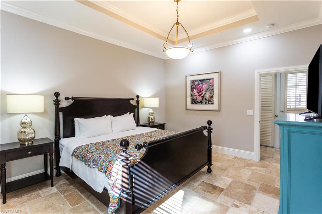 2225 23rd Street Southwest Naples, FL 34117 - Photo 23 of 44 a bedroom with a bed and a chandelier