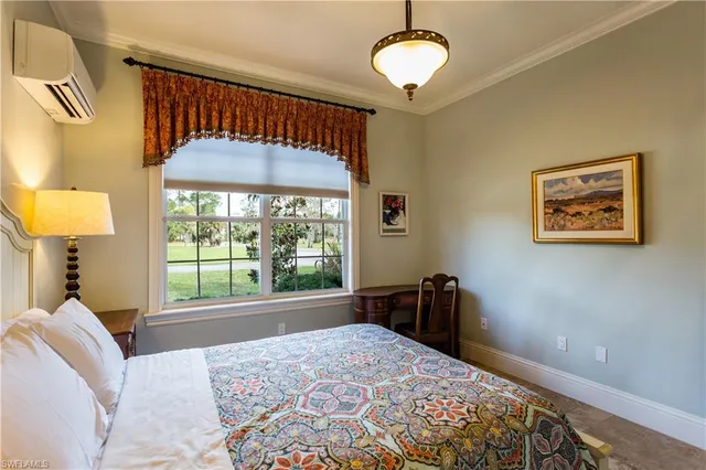 a bedroom with a bed and a dresser next to a window