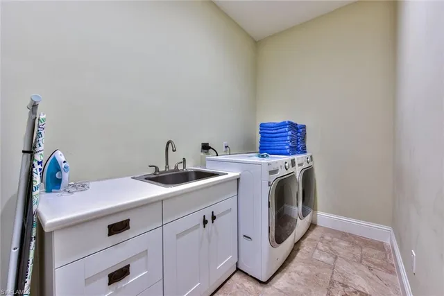 a utility room with sink dryer and washer