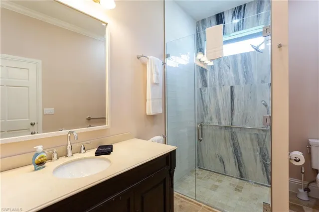 a bathroom with a sink vanity granite tub shower and a mirror