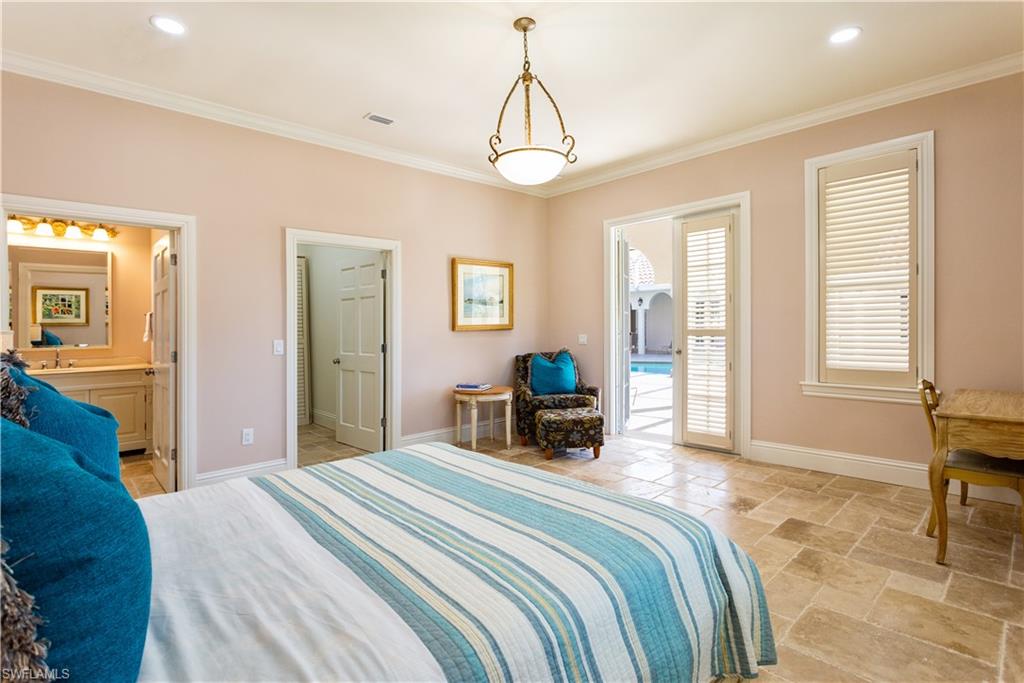 2225 23rd Street Southwest Naples, FL 34117 - Photo 43 of 44 a bedroom with a bed and a chandelier