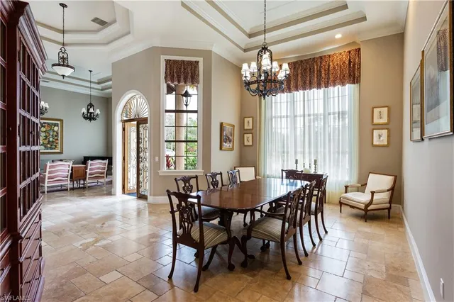 a view of a dining room with furniture a chandelier and large mirror