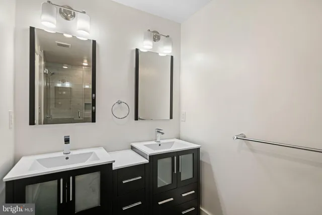 a bathroom with a double vanity sink and a mirror