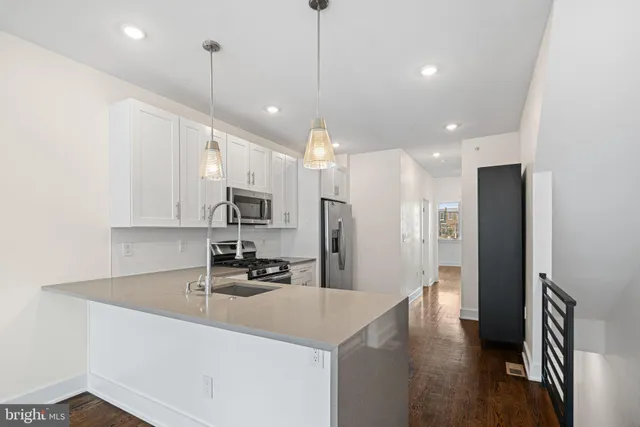 a kitchen with stainless steel appliances a refrigerator sink and stove
