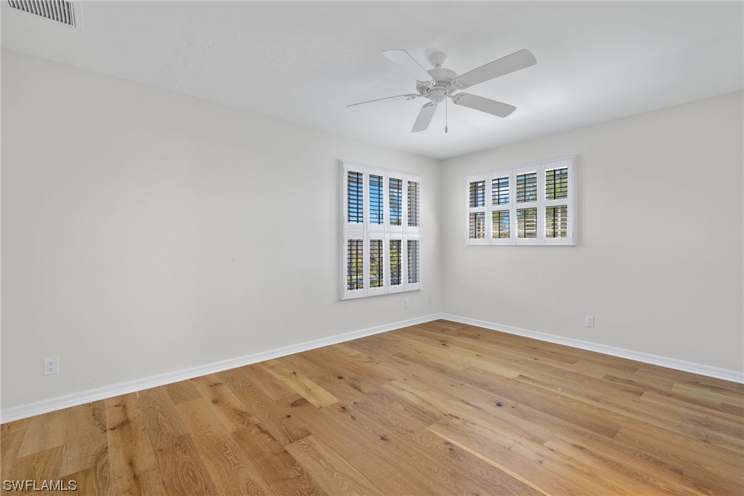 657 Rabbit Road Sanibel, FL 33957 - Photo 22 of 37 a view of an empty room with wooden floor and a window
