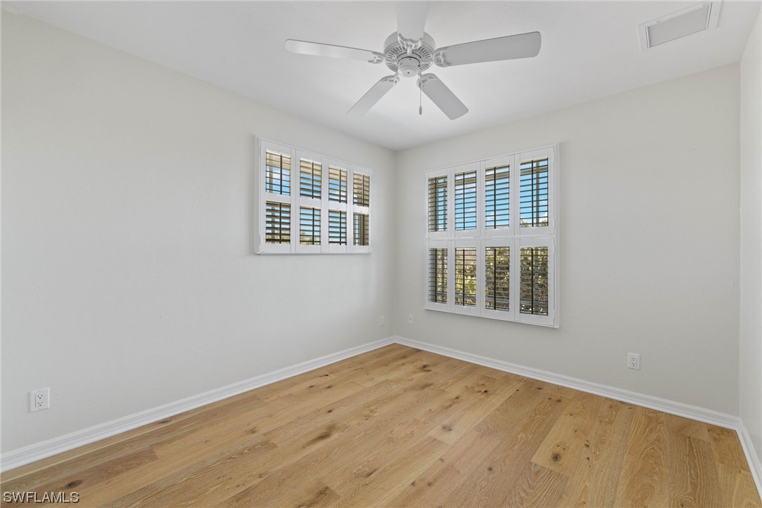 657 Rabbit Road Sanibel, FL 33957 - Photo 27 of 37 an empty room with wooden floor fan and windows