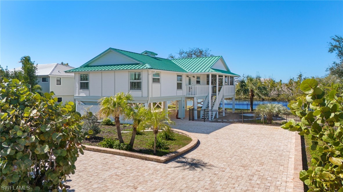 657 Rabbit Road Sanibel, FL 33957 - Photo 30 of 37 a front view of a house with a yard and potted plants