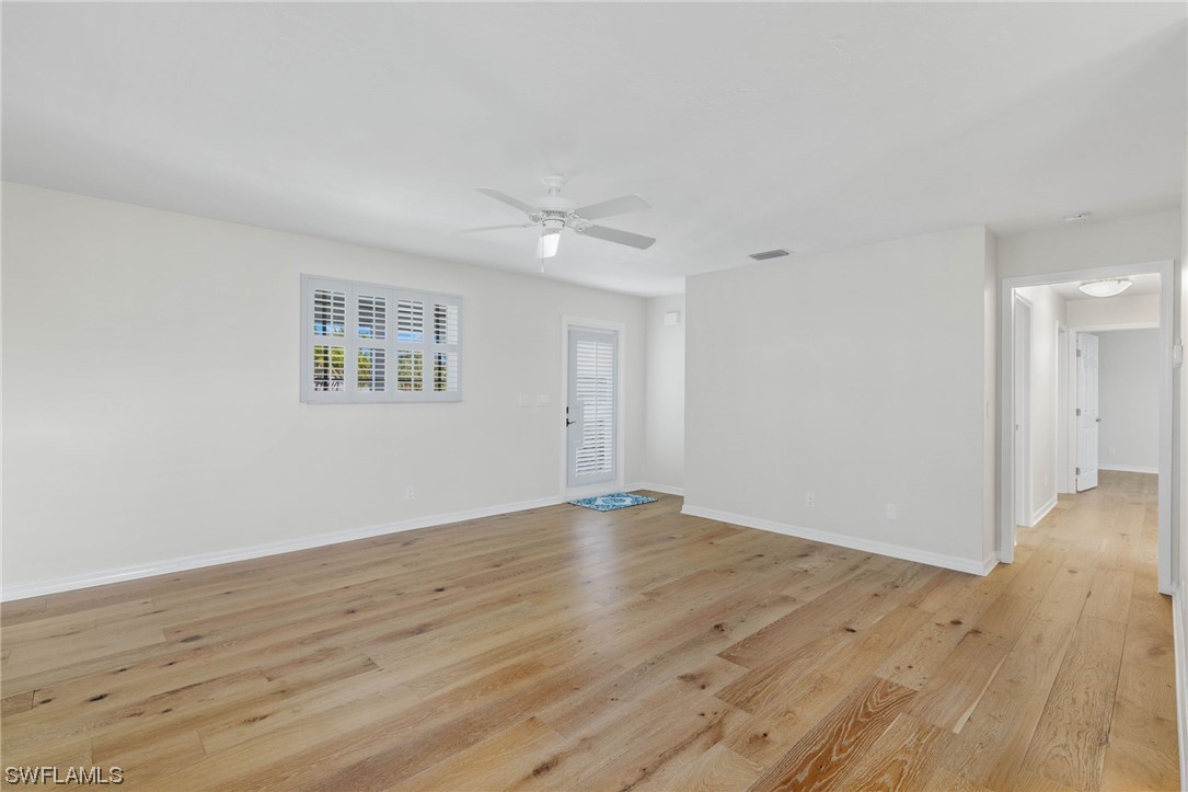 657 Rabbit Road Sanibel, FL 33957 - Photo 7 of 37 a view of an empty room with wooden floor and a window
