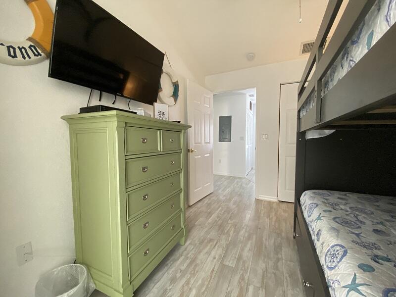 343 Ocean Park Lane, Unit V110 Cape Canaveral, FL 32920 - Photo 13 of 25 a bedroom with a bed and wooden floor