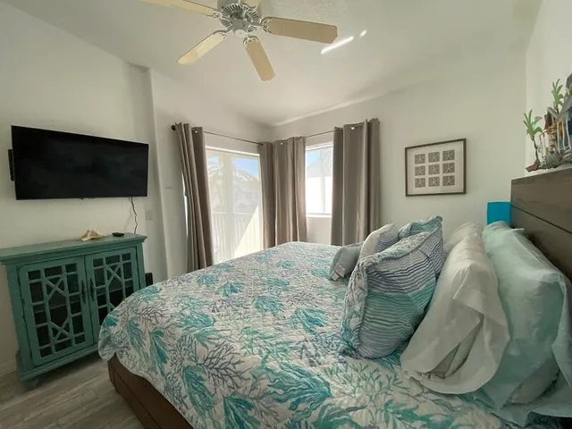 a spacious bedroom with a bed and a flat screen tv