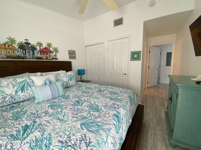 343 Ocean Park Lane, Unit V110 Cape Canaveral, FL 32920 - Photo 17 of 25 a bedroom with a bed and a painting on the wall