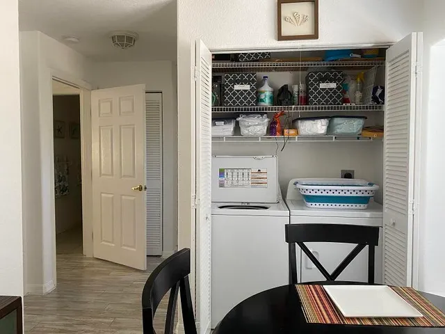 a view of table in kitchen with wooden floor and cabinets