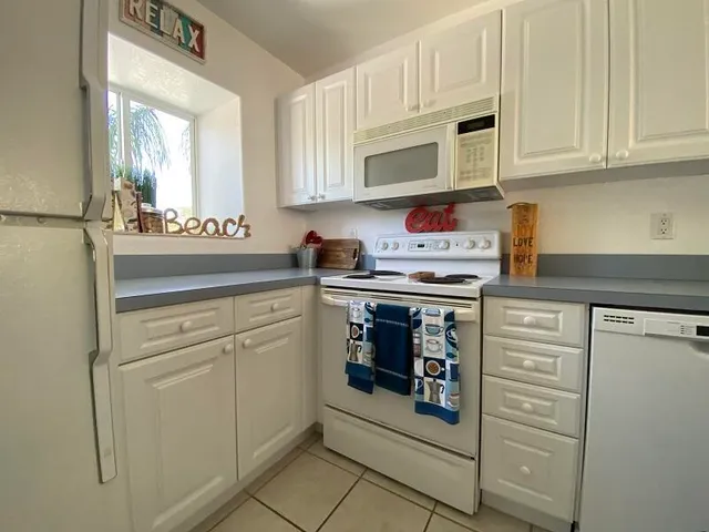 a kitchen with stainless steel appliances granite countertop a refrigerator and cabinets