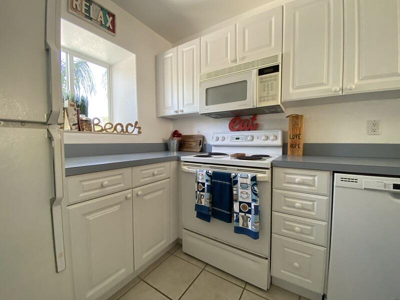 343 Ocean Park Lane, Unit V110 Cape Canaveral, FL 32920 - Photo 21 of 25 a kitchen with stainless steel appliances granite countertop a refrigerator and cabinets