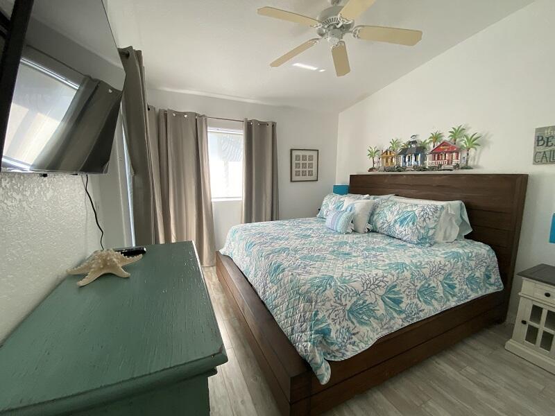 343 Ocean Park Lane, Unit V110 Cape Canaveral, FL 32920 - Photo 4 of 25 a bedroom with a bed and a flat screen tv