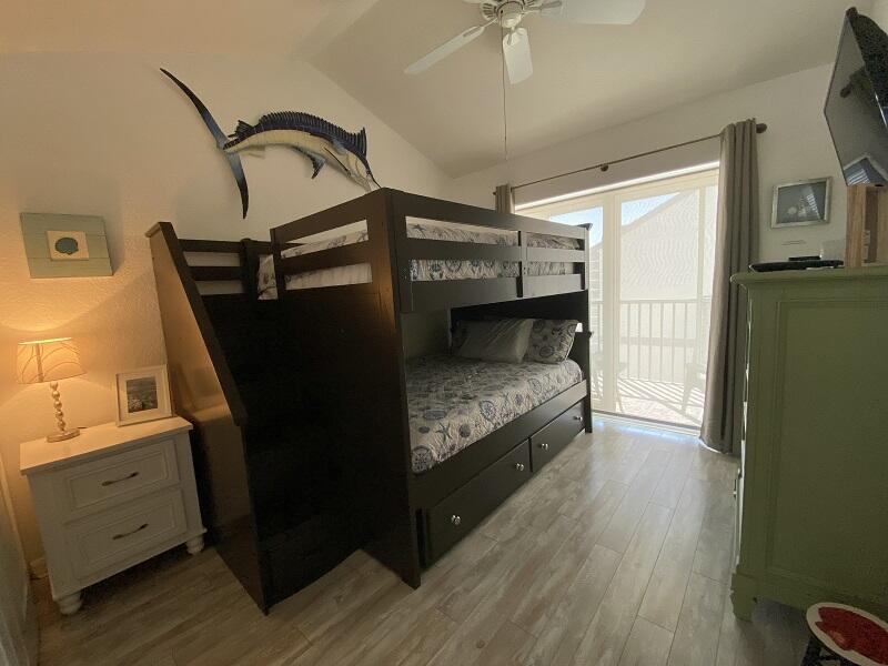 343 Ocean Park Lane, Unit V110 Cape Canaveral, FL 32920 - Photo 5 of 25 a bedroom with bed and wooden floor