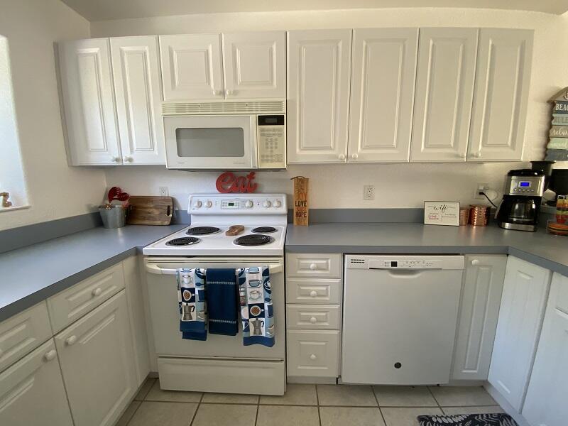 343 Ocean Park Lane, Unit V110 Cape Canaveral, FL 32920 - Photo 6 of 25 a kitchen with white cabinets and white appliances