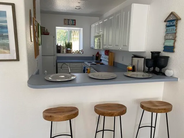 a kitchen with a dining table chairs and a chandelier