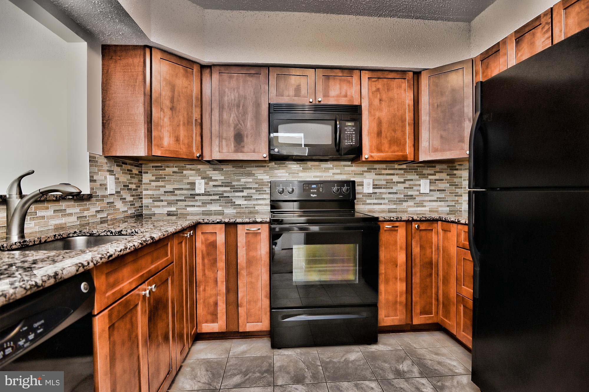 5505 Seminary Road, Unit 1817N Falls Church, VA 22041 - Photo 2 of 31 a kitchen with granite countertop stainless steel appliances and wooden cabinets