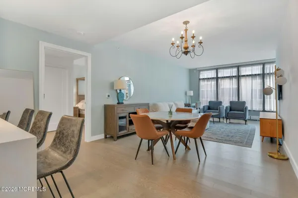 a dining room with furniture a chandelier and wooden floor