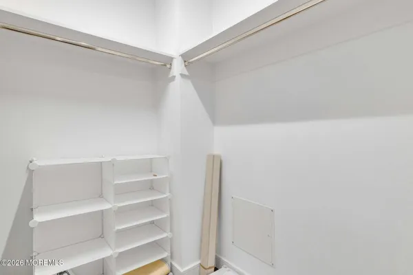 a view of walk in closet with empty racks