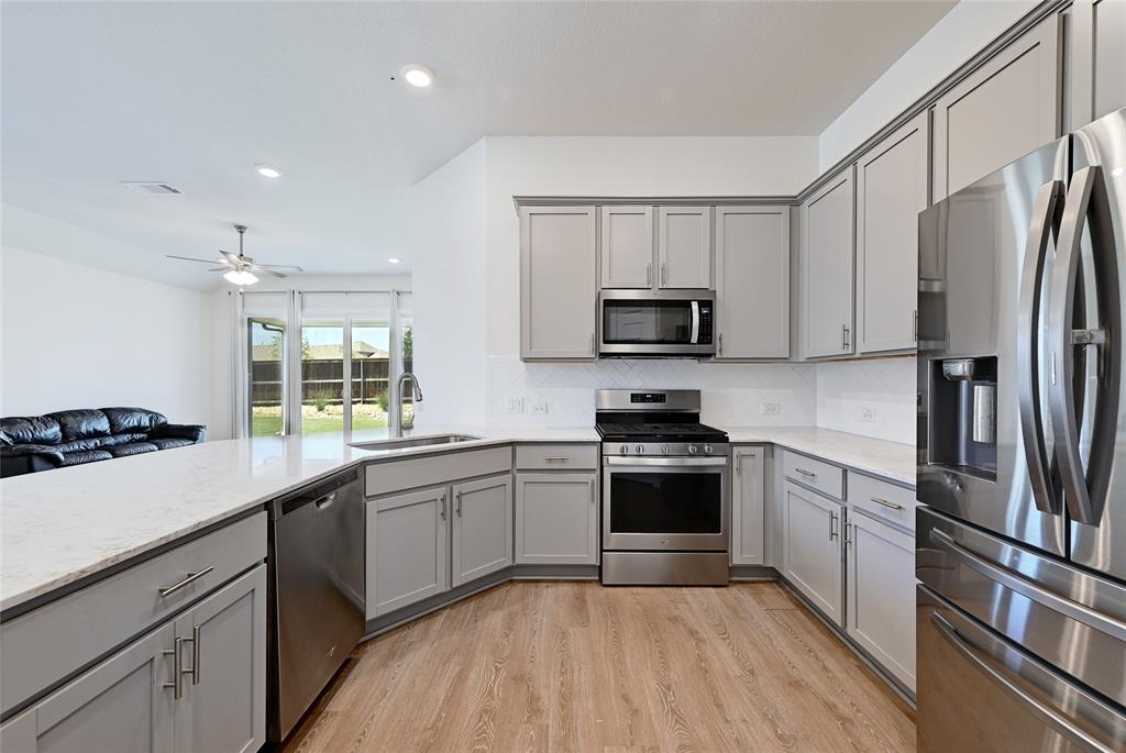 2133 Alamar Walk Leander, TX 78641 - Photo 10 of 25 a kitchen with a sink stainless steel appliances and cabinets