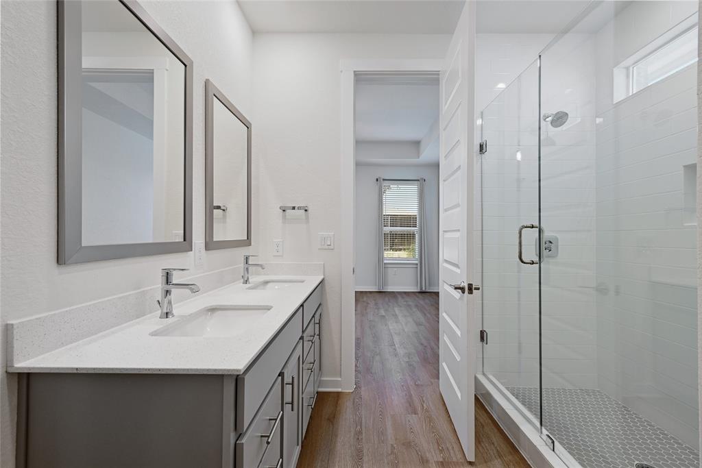 2133 Alamar Walk Leander, TX 78641 - Photo 12 of 25 a bathroom with a double vanity sink a mirror and a shower