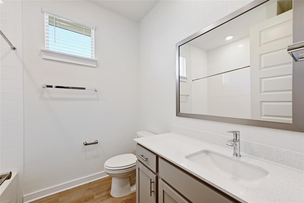 2133 Alamar Walk Leander, TX 78641 - Photo 17 of 25 a bathroom with a granite countertop sink toilet and a mirror