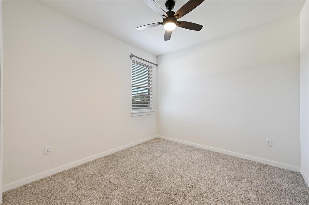 2133 Alamar Walk Leander, TX 78641 - Photo 19 of 25 an empty room with a window and a fan