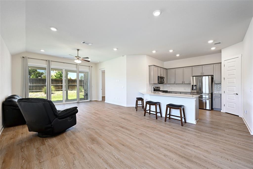 2133 Alamar Walk Leander, TX 78641 - Photo 25 of 25 a living room with stainless steel appliances kitchen island granite countertop furniture and wooden floor