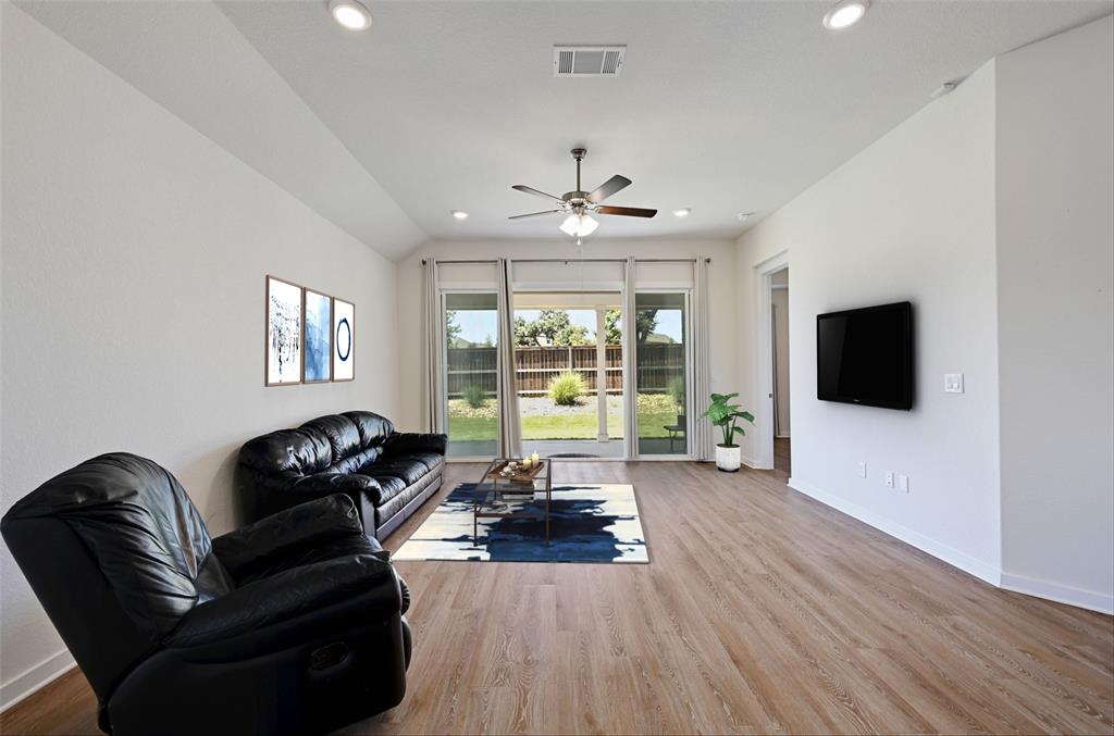 2133 Alamar Walk Leander, TX 78641 - Photo 7 of 25 a living room with furniture a flat screen tv and a large window