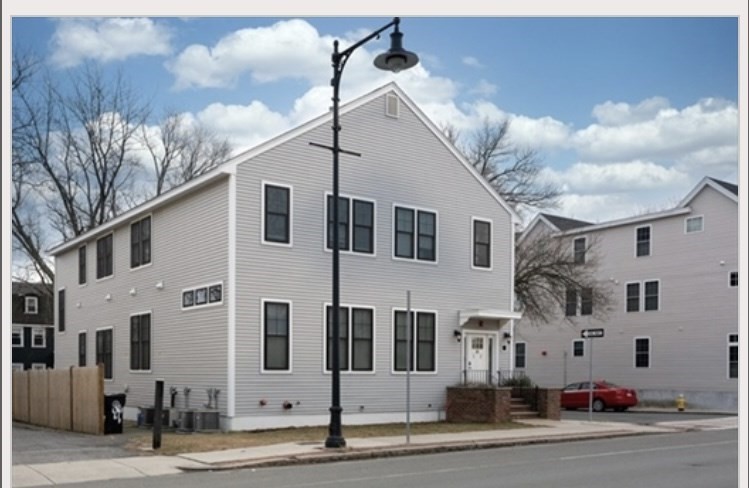 a view of a white house with a road
