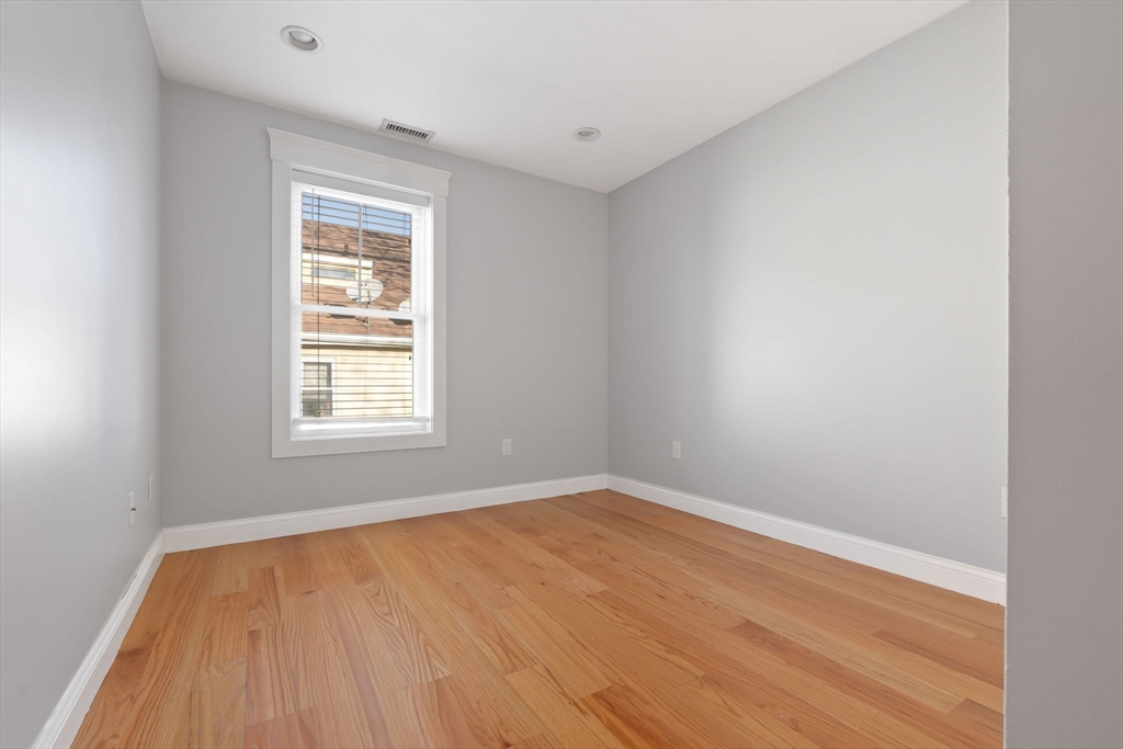 85 Bridge Street, Unit 4 Salem, MA 01970 - Photo 17 of 31 an empty room with wooden floor and windows
