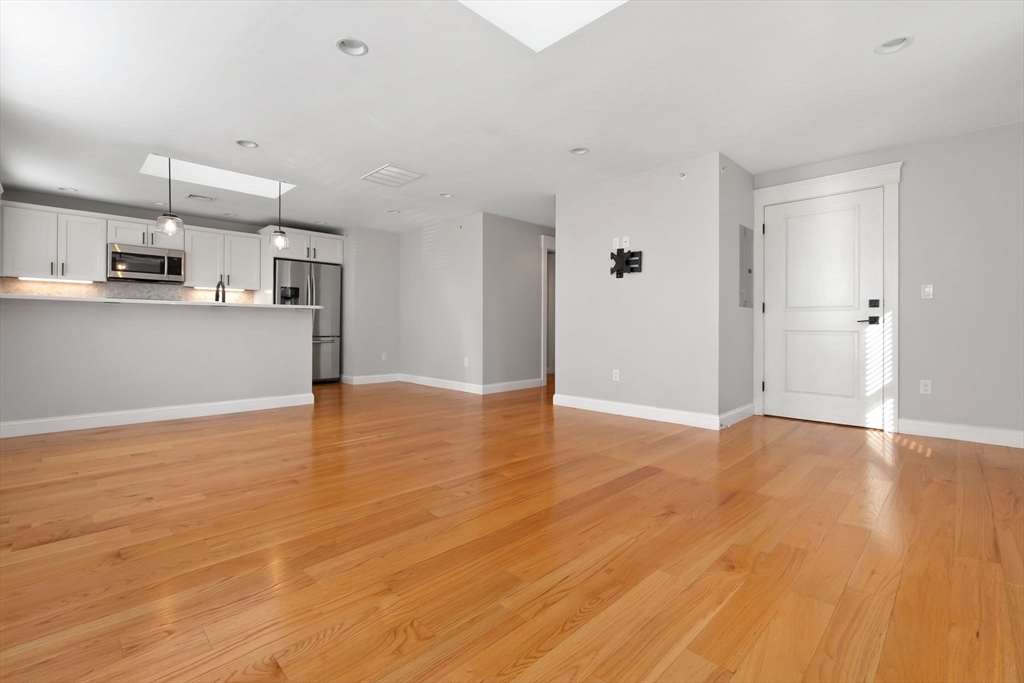 85 Bridge Street, Unit 4 Salem, MA 01970 - Photo 5 of 31 a view of kitchen and empty room with wooden floor