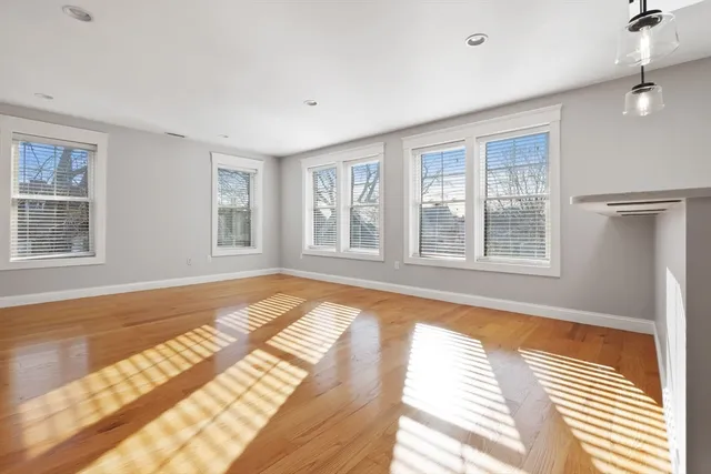a view of a bedroom with wooden floor and windows